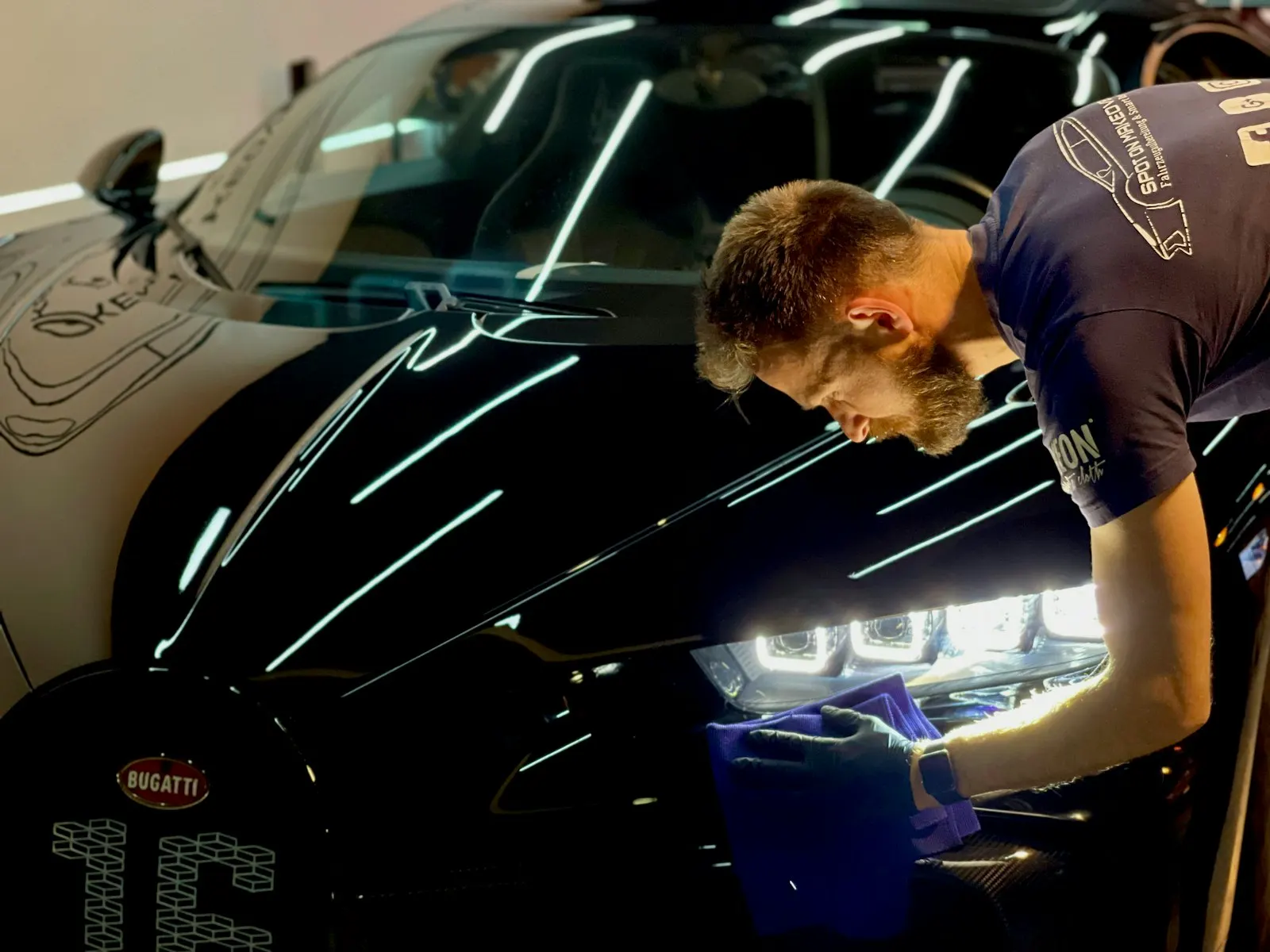 Detailer inspiserer svart lakk med lampe